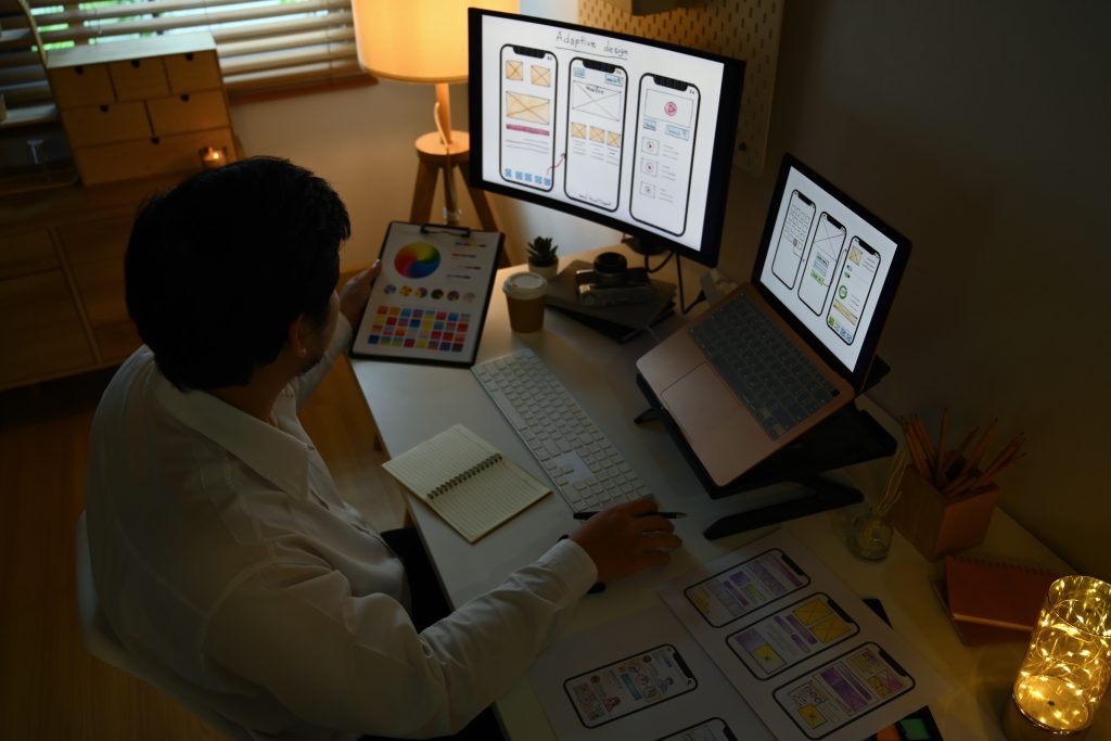 Young Asian Male Designer Working On Mobile Application Software Design Project In Dark Room