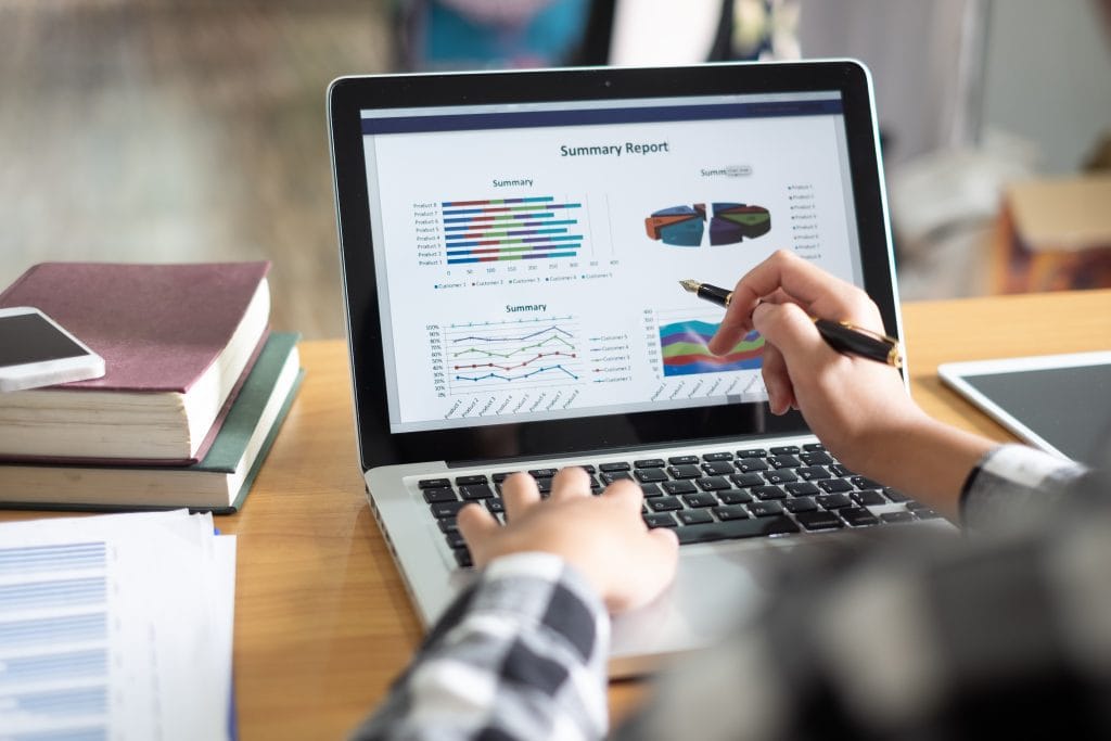 Business Woman Analyzing Investment Charts On Laptop Screen At M