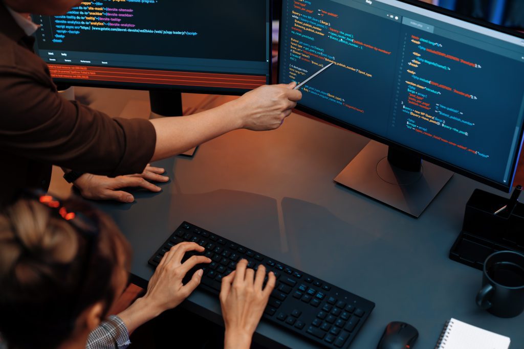 Top View IT Developers Discussing With Point Website Coding System. Infobahn.