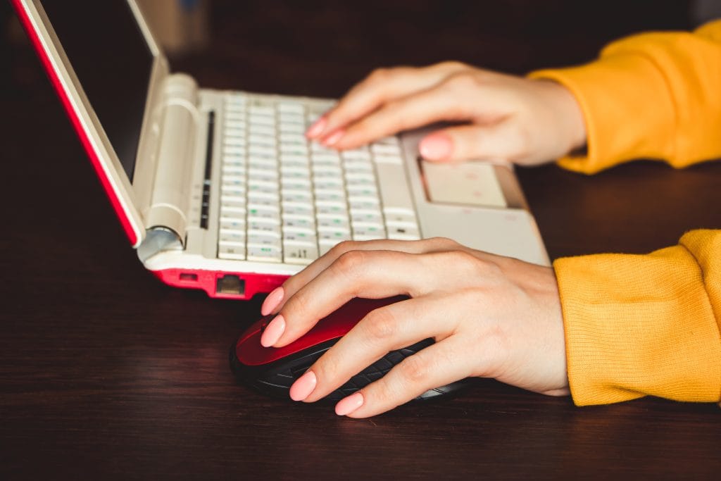 International Left Handers Day. Business Woman Works With Laptop At Home And Holds Computer Mouse In Her Left Hand.